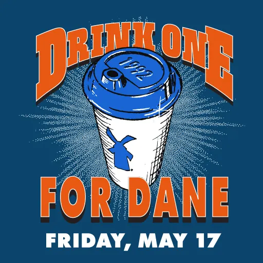 Blue coffee cup with Dutch windmill logo and orange text "DRINK ONE FOR DANE" with date "FRIDAY, MAY 17"