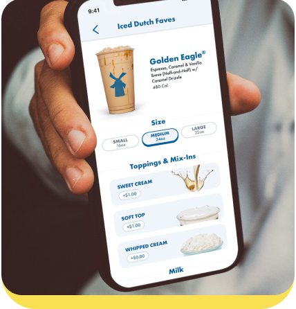 Hand holding phone displaying Dutch Bros coffee app with Golden Eagle drink options and topping selections
