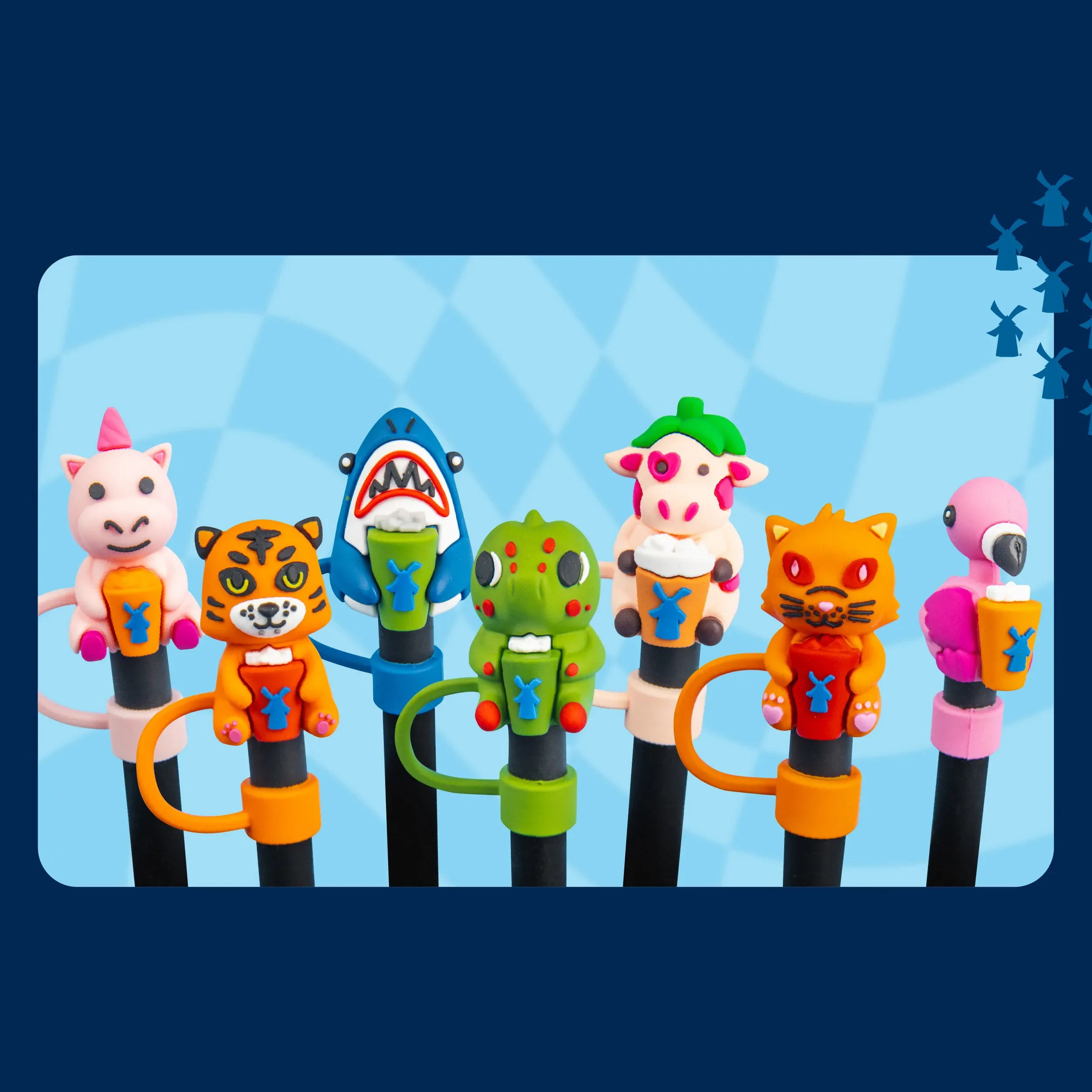 Seven colorful animal-shaped straw toppers including a unicorn, tiger, shark, dinosaur, cow, cat, and flamingo on a blue background.