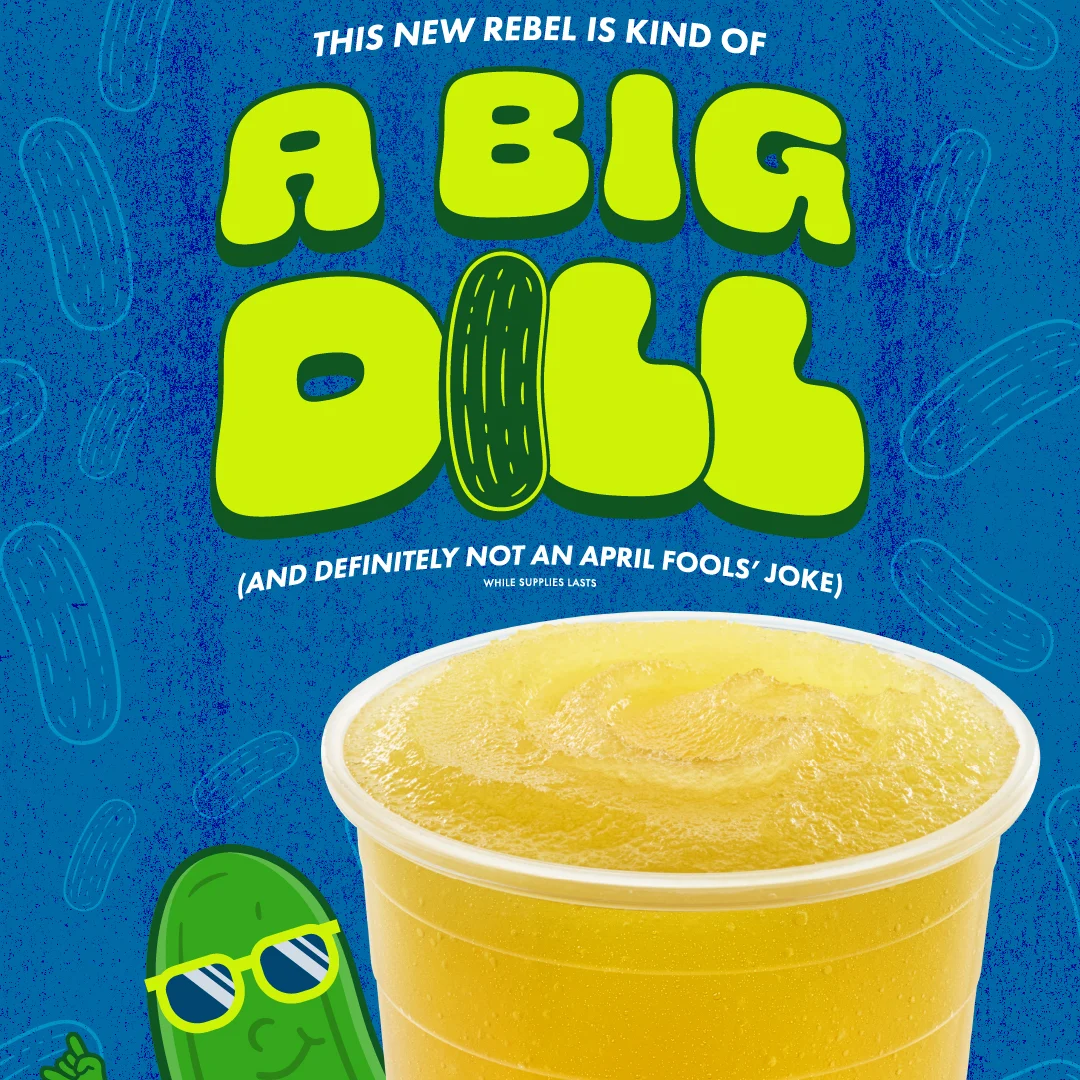 Yellow drink in clear cup with bright green "A BIG DILL" text on blue background, cartoon pickle with sunglasses in corner.