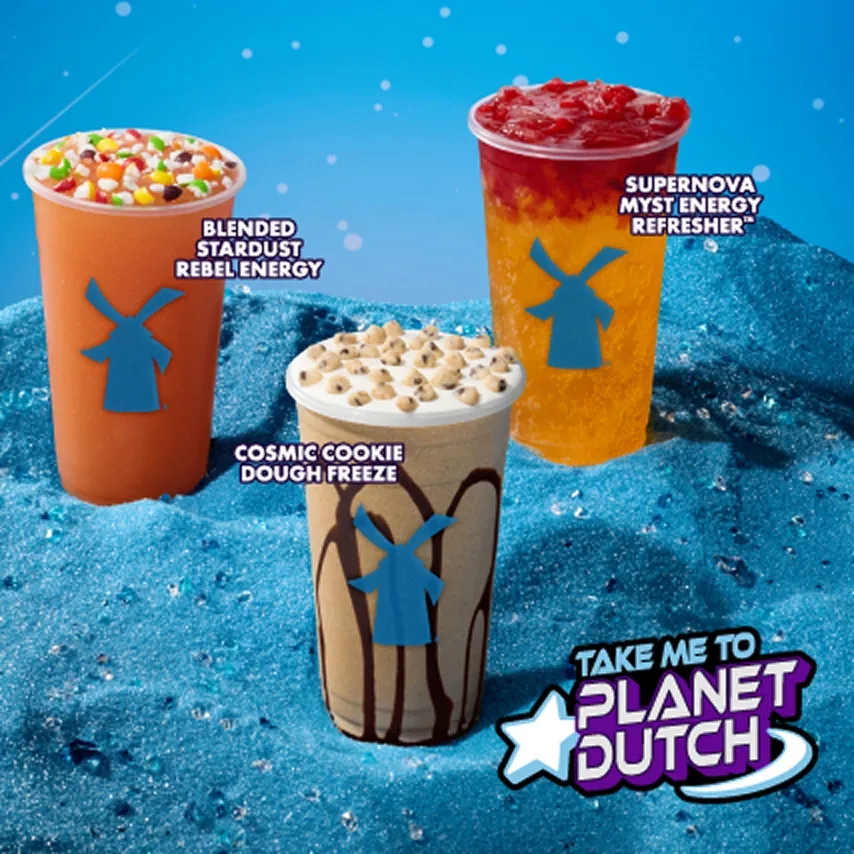 Three Dutch Bros drinks on icy blue surface: Blended Stardust Rebel Energy, Supernova Myst Energy Refresher, and Cosmic Cookie Dough Freeze.