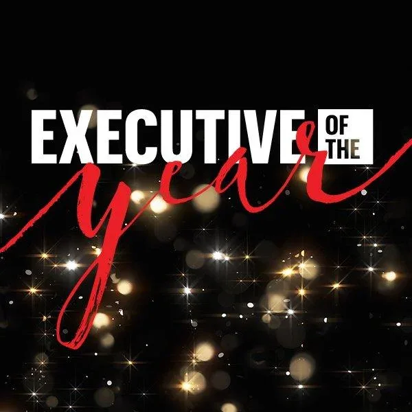 "Executive of the Year" text in white and red against a black background with gold sparkles and light bokeh effects.