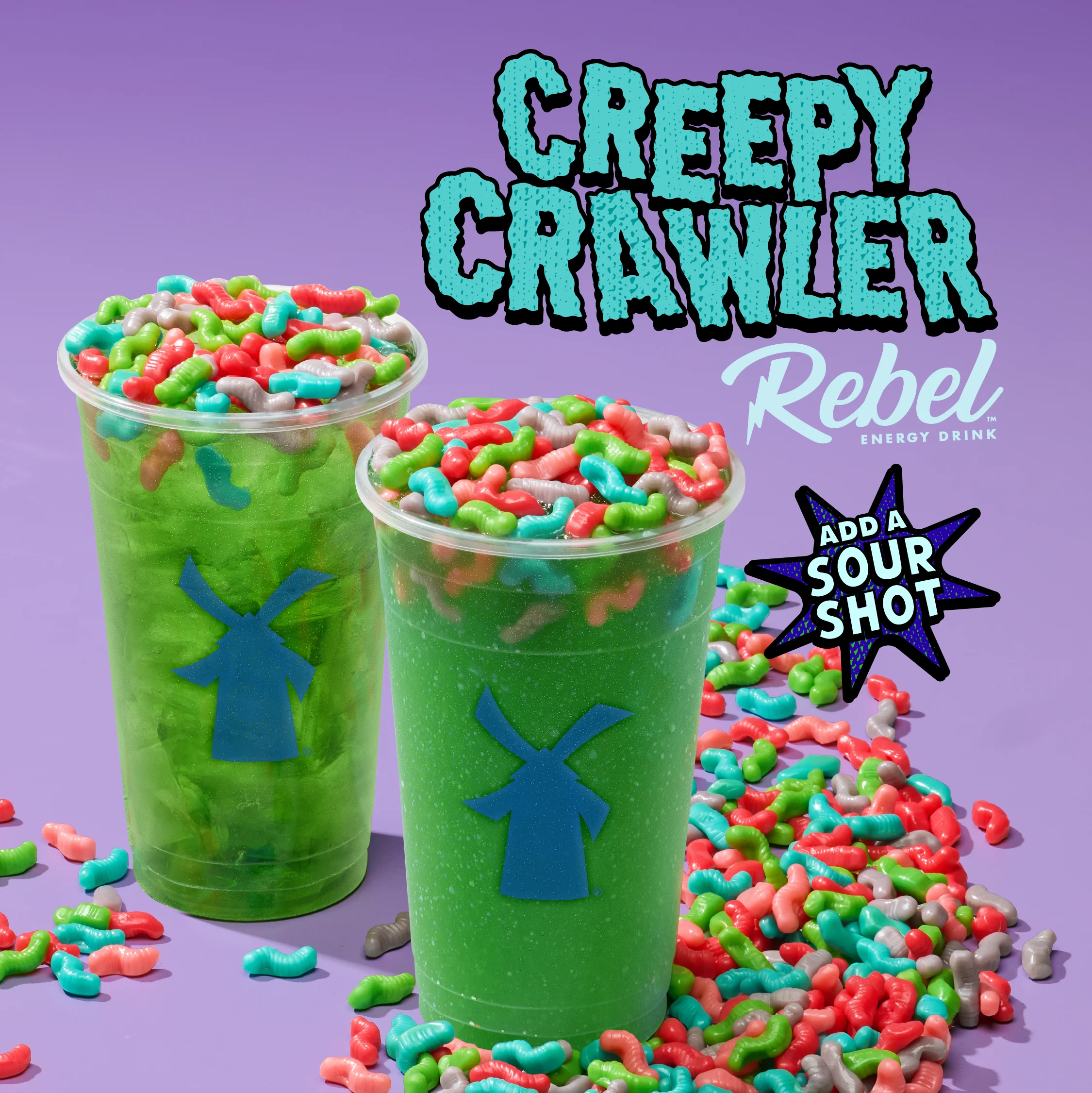 Two green Creepy Crawler Rebel Energy Drinks topped with colorful gummy worms on a purple background.