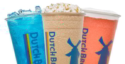Three colorful Dutch Bros drinks - blue, tan, and orange beverages in branded cups with whipped cream topping.