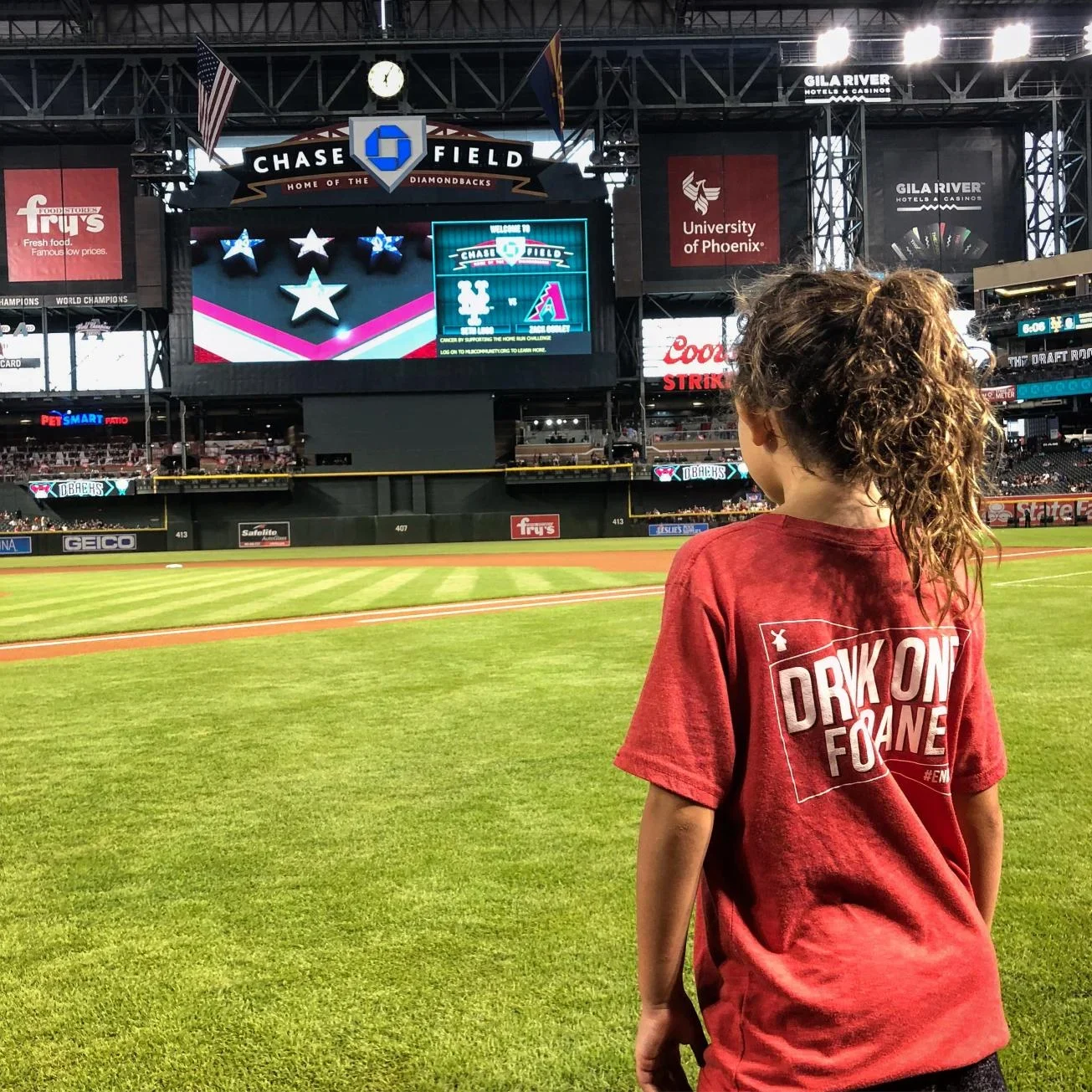 Person in red shirt watching a baseball game at Chase Field, home of the Arizona Diamondbacks.