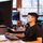 A man sitting at a desk working intently on the computer