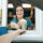 A smiling broista hands a drink out the window