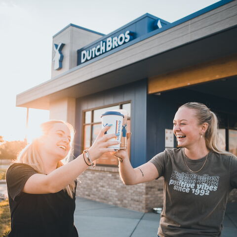 Two women cheering outside of Dutch Bros coffee 
