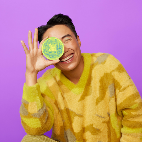 Image shows a smiling person holding our February sticker of the month