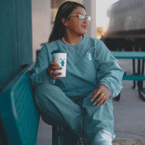 Girl on a bench holding a hot coffee