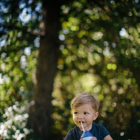 A baby drinks a Dutch Bros kid drink out of a straw