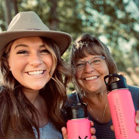 Two Dutch Bros customers pose with their pink insulated bottles