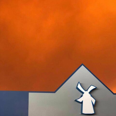 A Dutch Bros location is shown with a fiery red sky in the background from wildfires in California