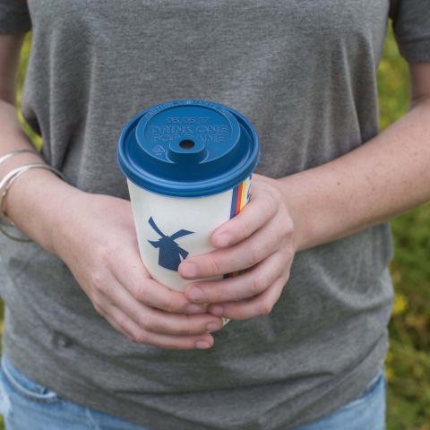 a person holds a Dutch Bros hot coffee cup
