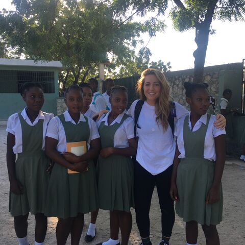 Dutch Bros business coach Rennika Doty poses with students from Haiti