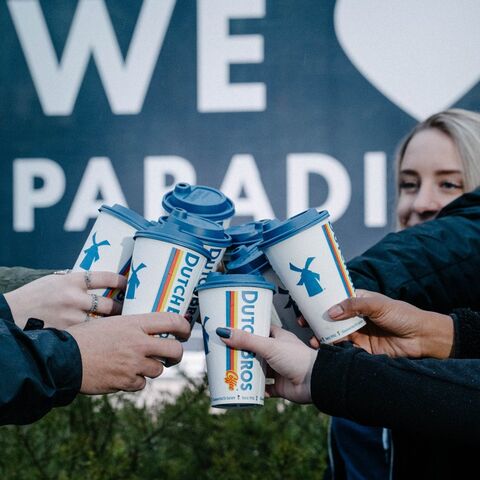 a group of dutch bros customers cheers their cups