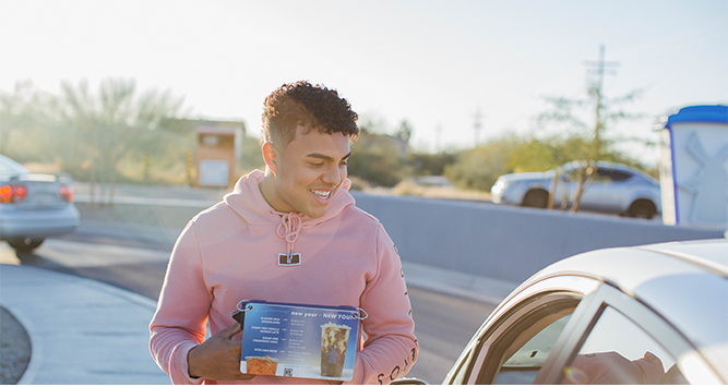 A Broista taking orders at a stand in the drive-thru lane